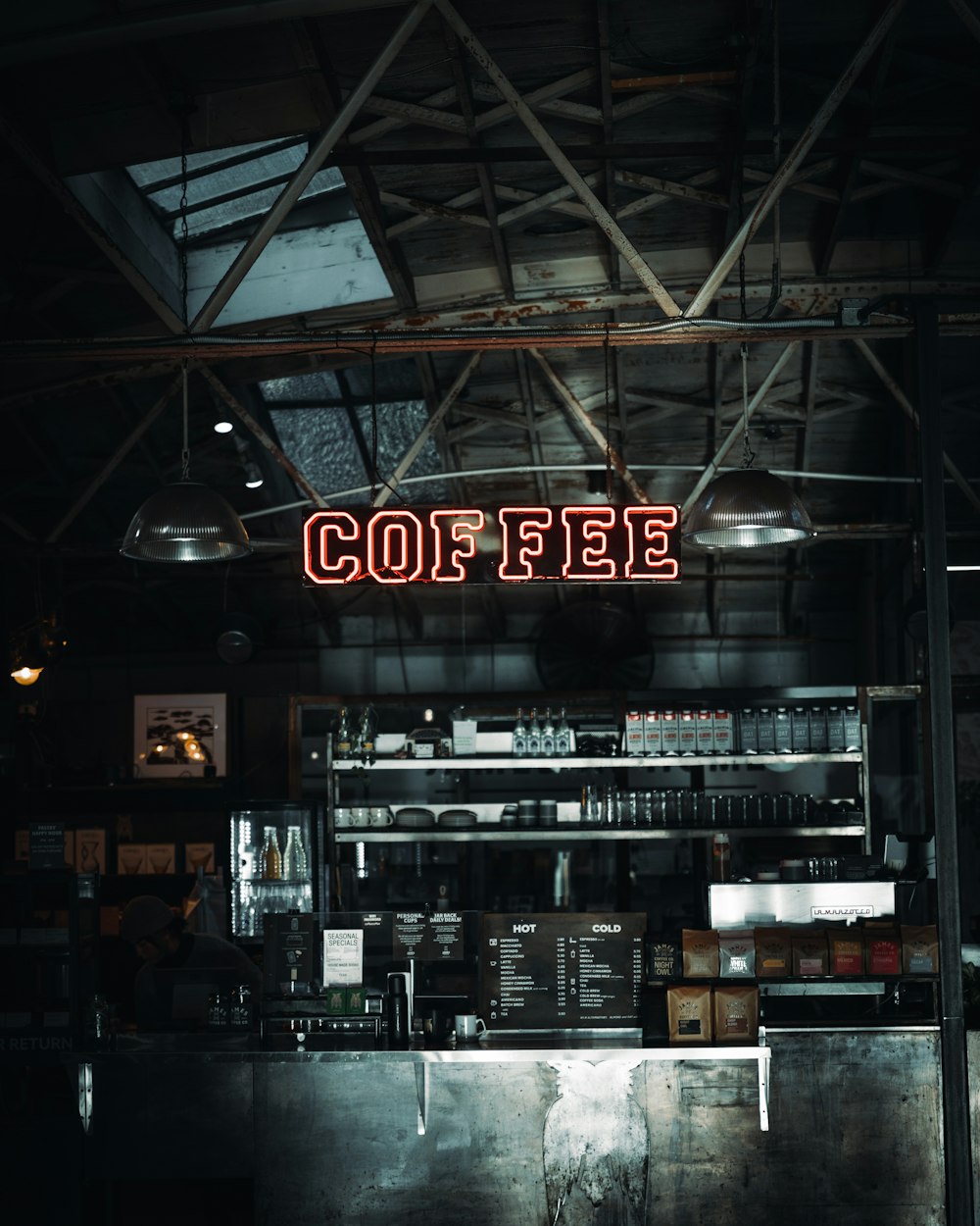 a coffee shop with a neon sign above the counter
