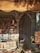 A cozy, small bookshop filled with towering stacks of books organized both on tables and inside open shelves. The scene is bathed in warm, golden light, with a partially open wooden door revealing more books stacked inside. The shop has an inviting, slightly cluttered but charming atmosphere.