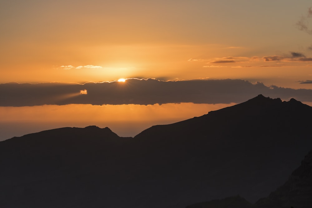 Il sole sta tramontando su una catena montuosa