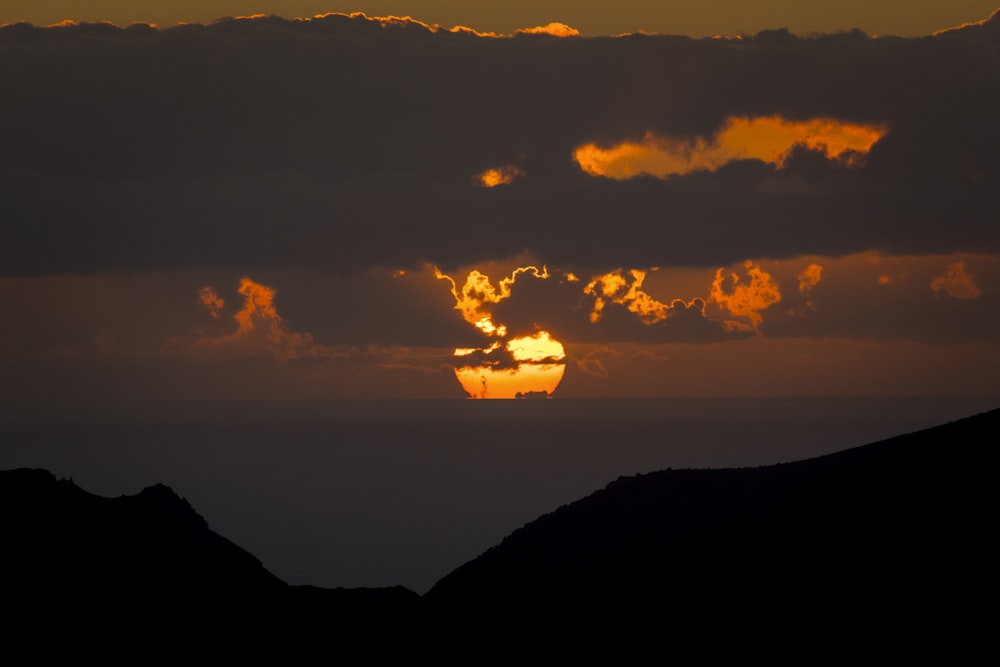 the sun is setting over the mountains in the distance