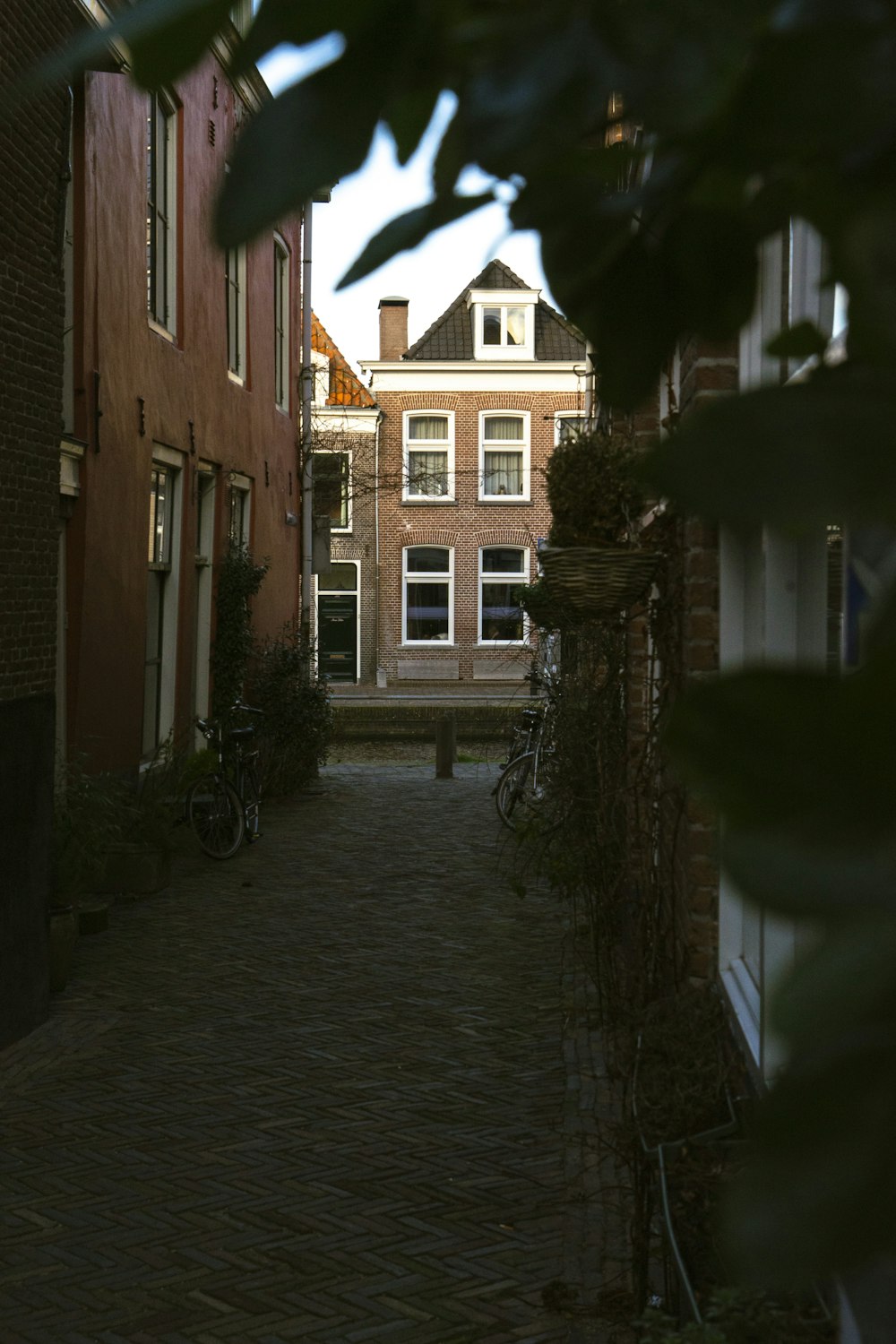 a narrow brick street with a building in the background