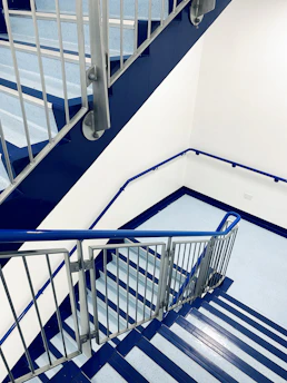 Close-up of a spotless staircase in a high-end commercial building with silver and dark blue accents.