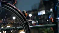 Detail of a motorcycle tire and brake disc with reflections of city lights