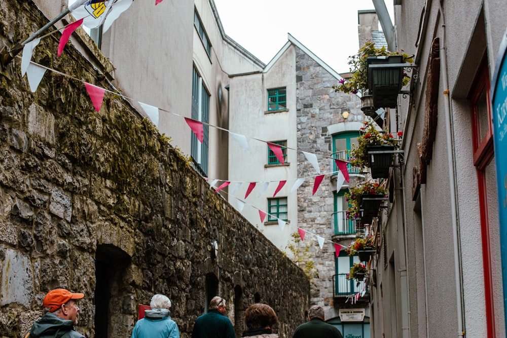 a group of people walking down a narrow street