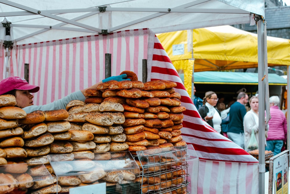 a woman standing behind a display of donuts