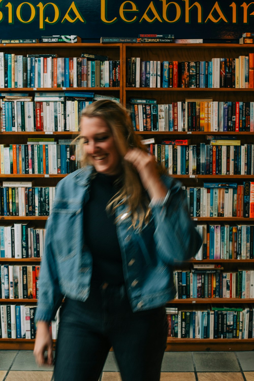 a woman standing in front of a book shelf