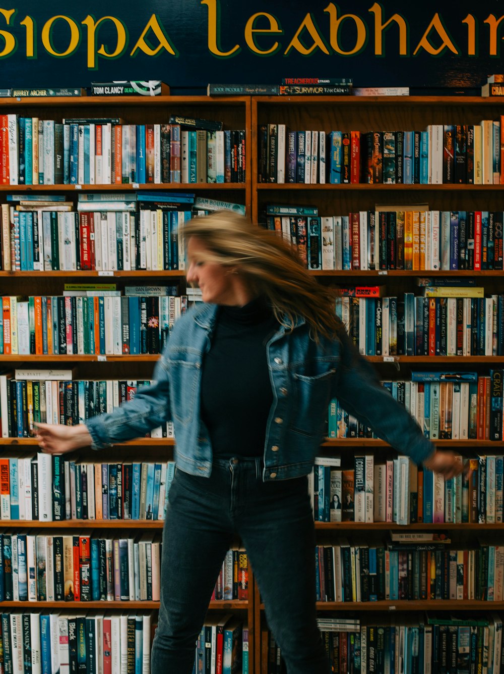 uma mulher em pé na frente de uma estante cheia de livros