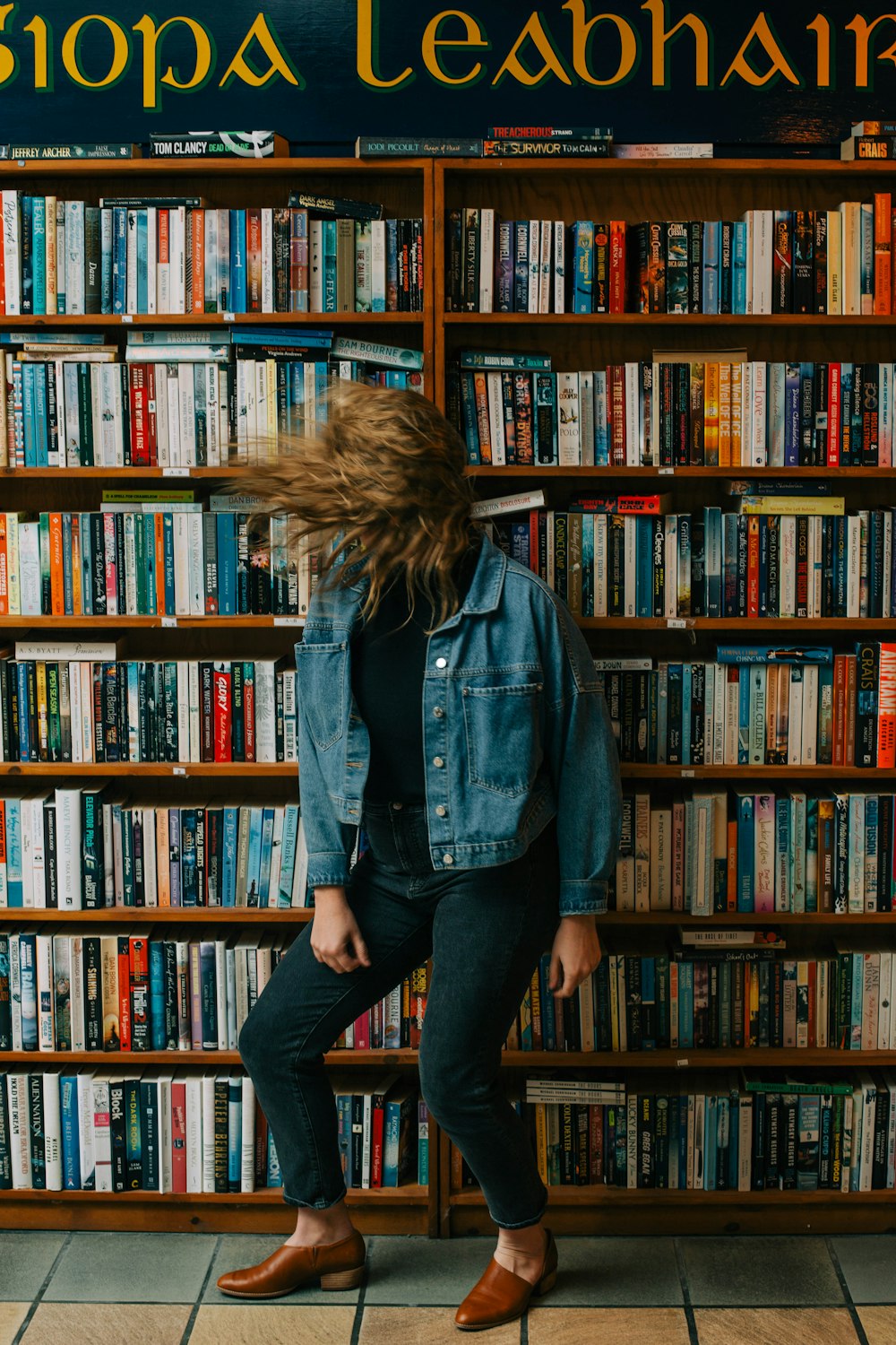 uma mulher em pé na frente de uma estante cheia de livros