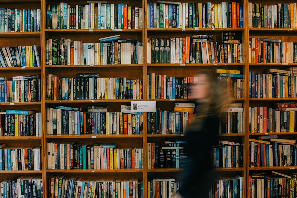 a blurry photo of a woman in front of a bookshelf