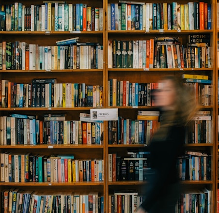 a blurry photo of a woman in front of a bookshelf