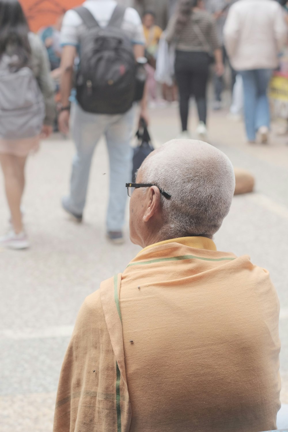 a man with glasses sitting on a bench