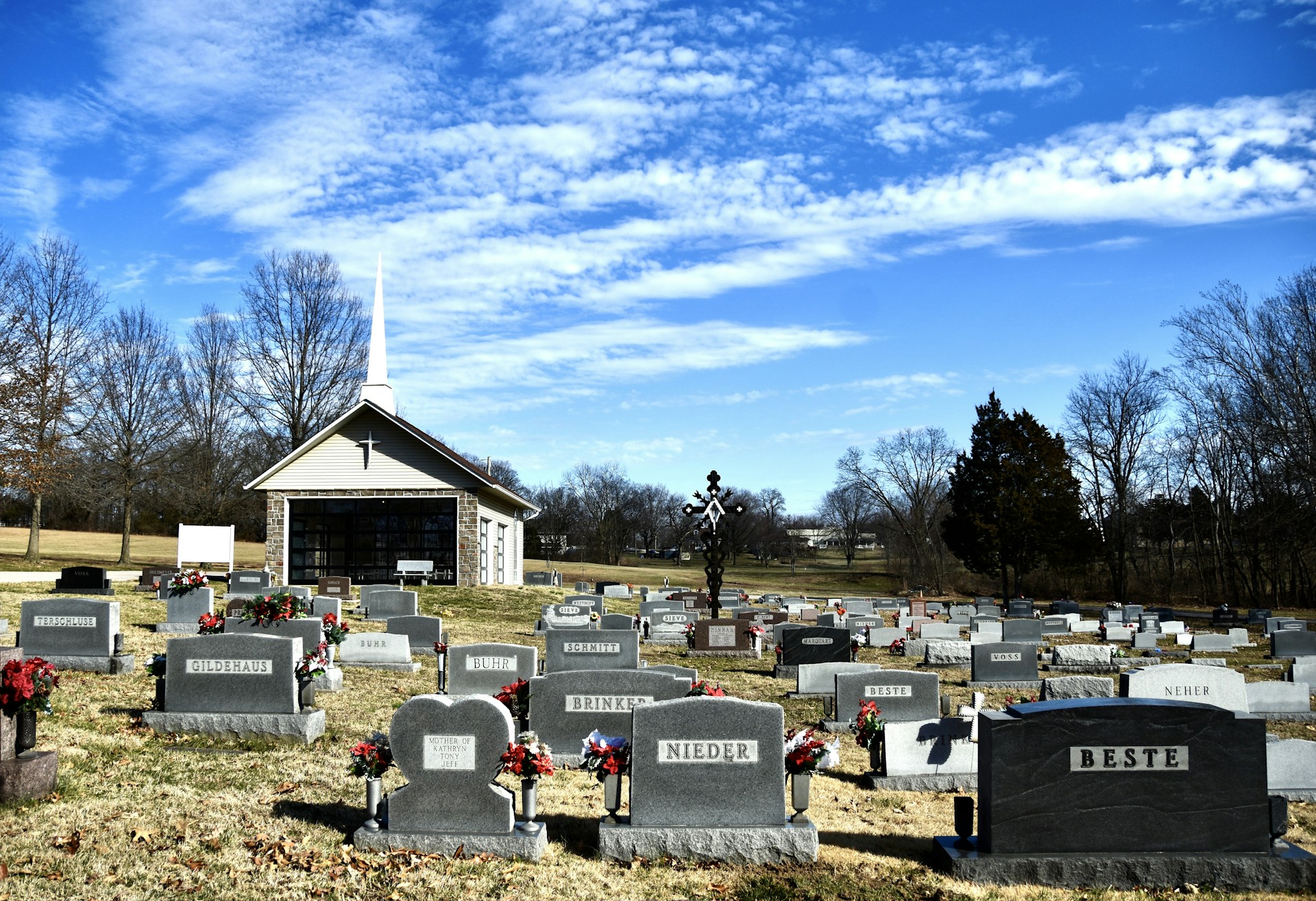 a cemetery with many headstones and flowers