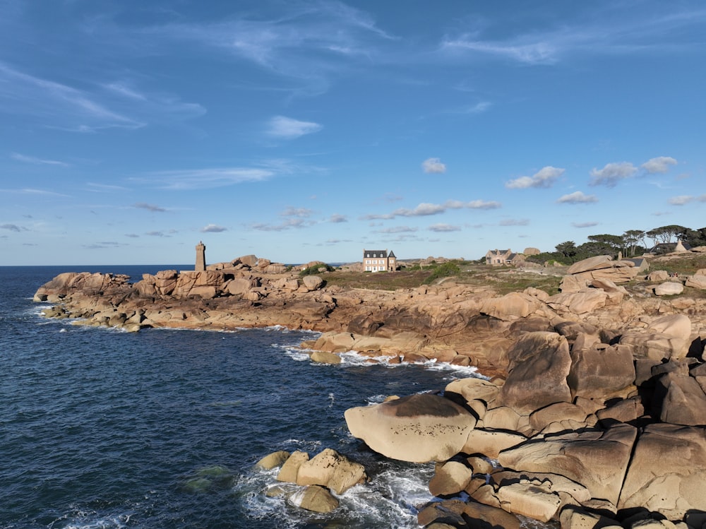 a rocky shore with a house on top of it