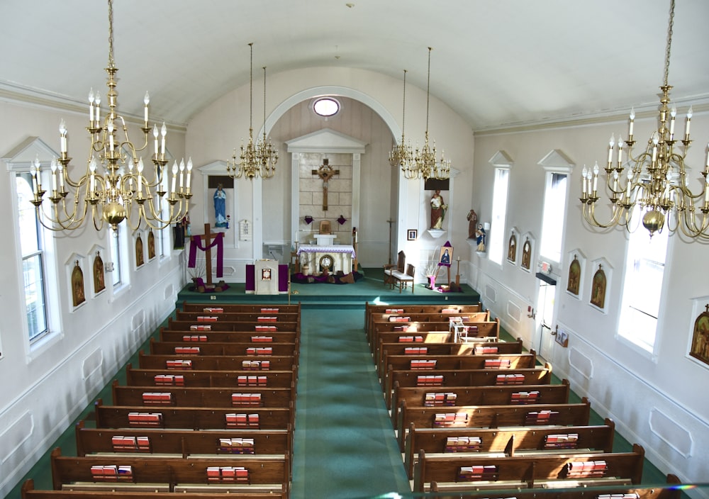 a church with rows of pews and chandeliers