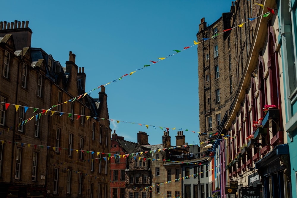 a city street lined with tall buildings and flags