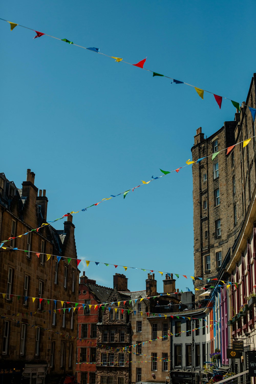 a group of buildings with flags hanging from them