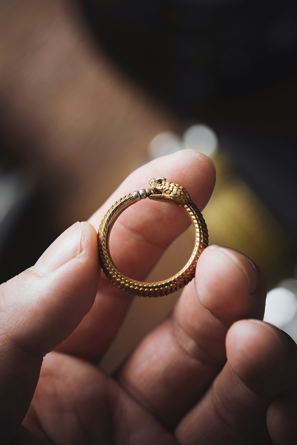 a person holding a gold ring in their hand