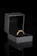 Close-up of a shimmering 24k gold dipped rose resting elegantly inside a sleek black case.