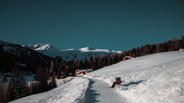 a couple of people riding skis down a snow covered slope