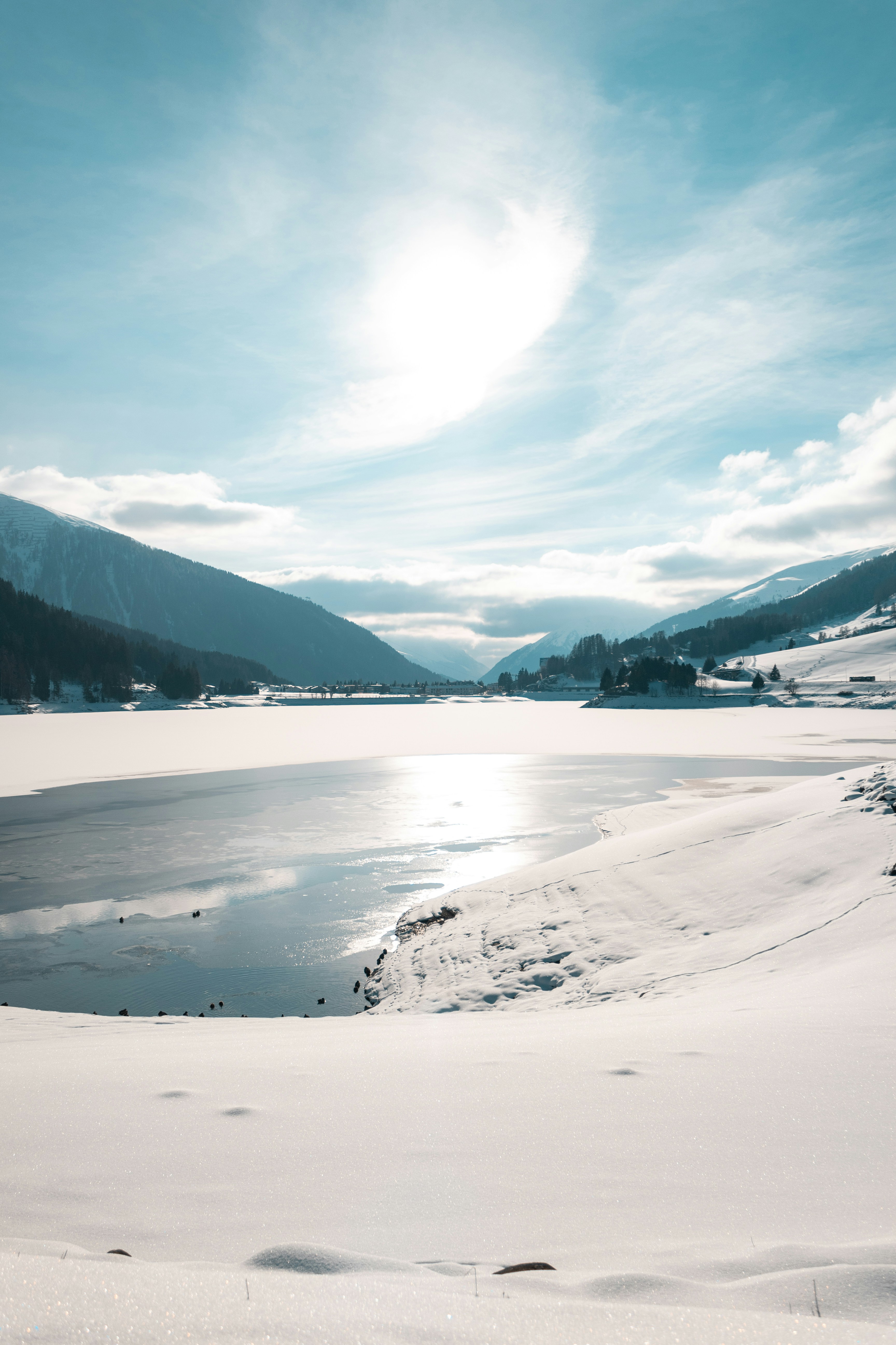 Ein See umgeben von schneebedeckten Bergen unter blauem Himmel