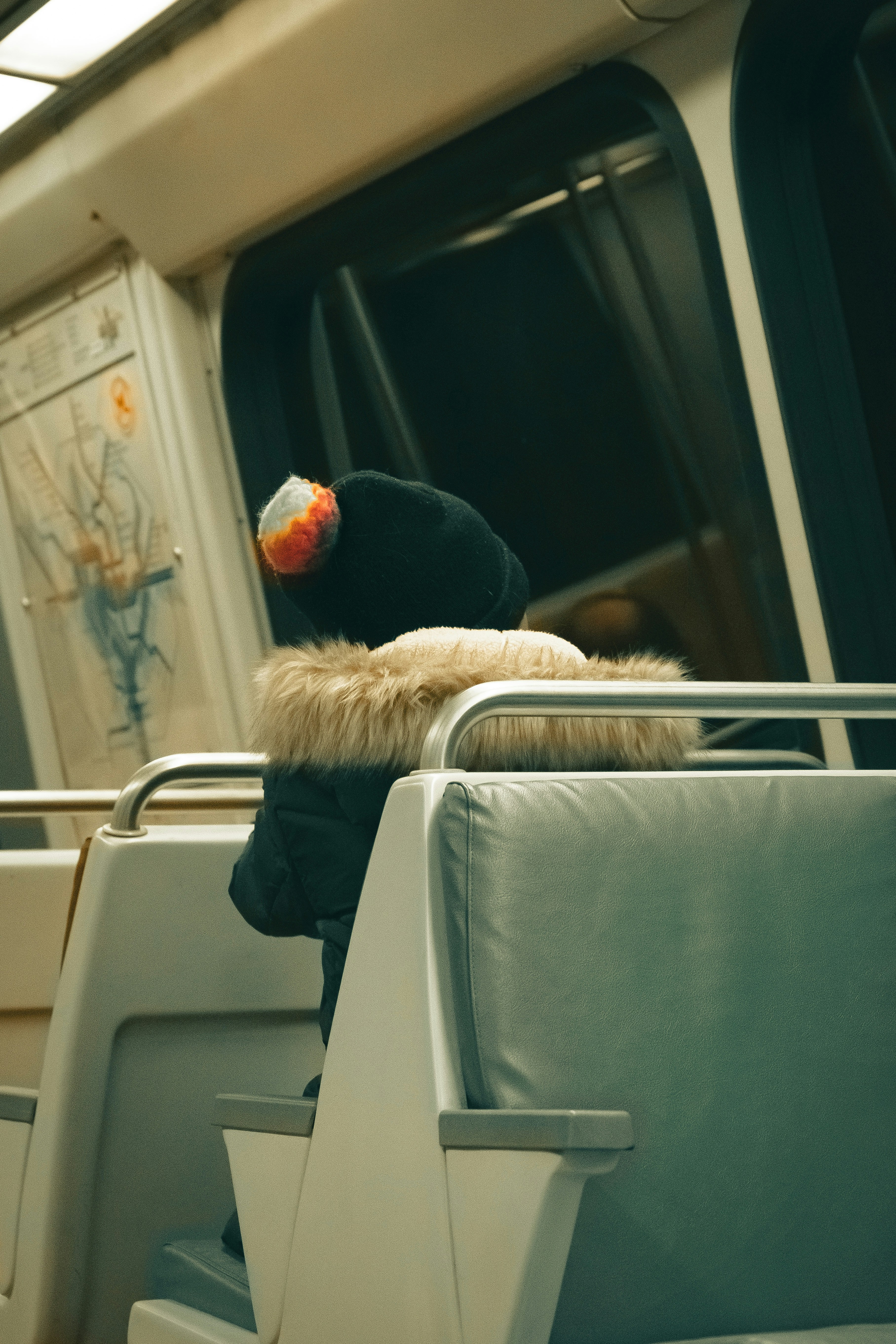 a person sitting on a train with a hat on