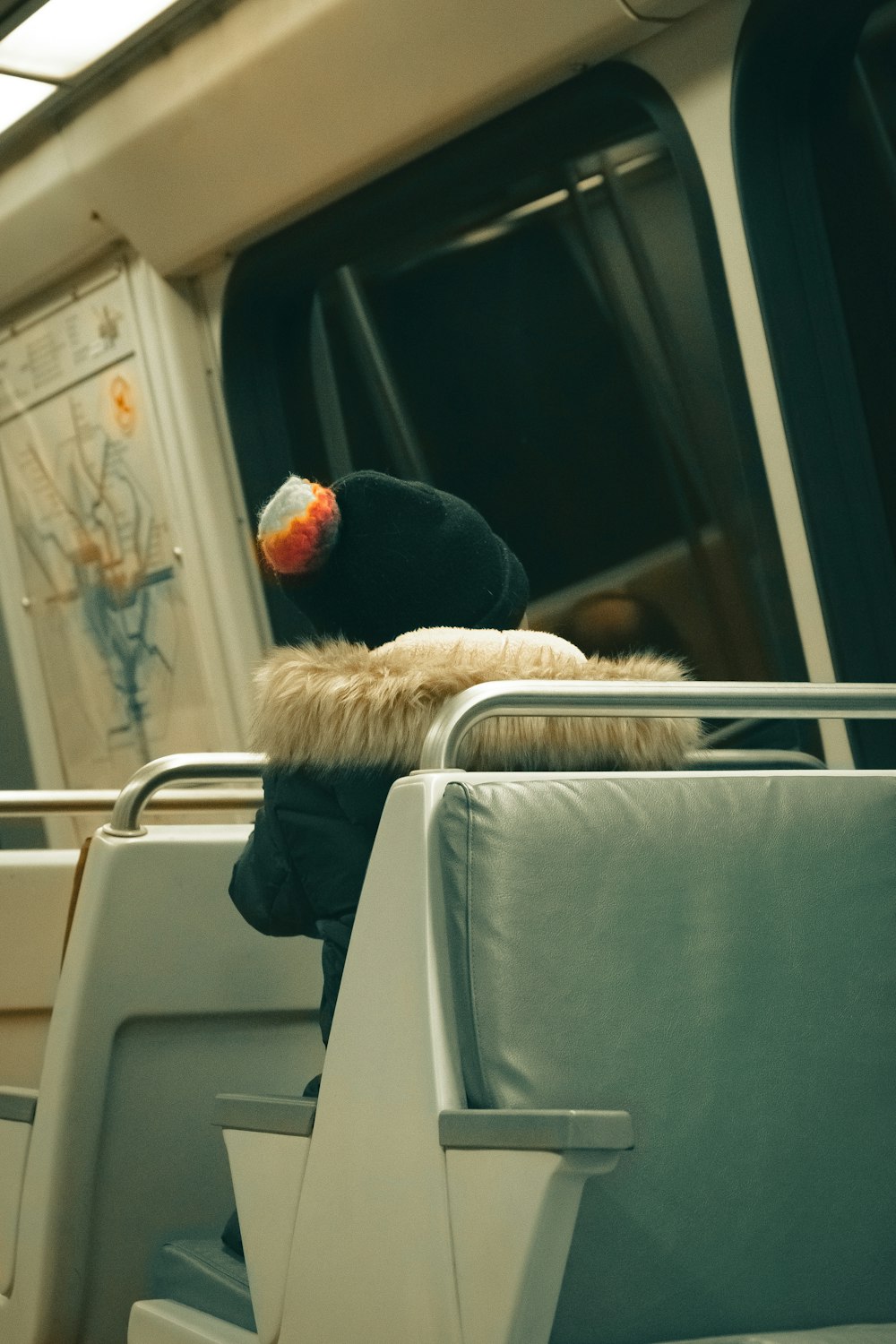 a person sitting on a train with a hat on