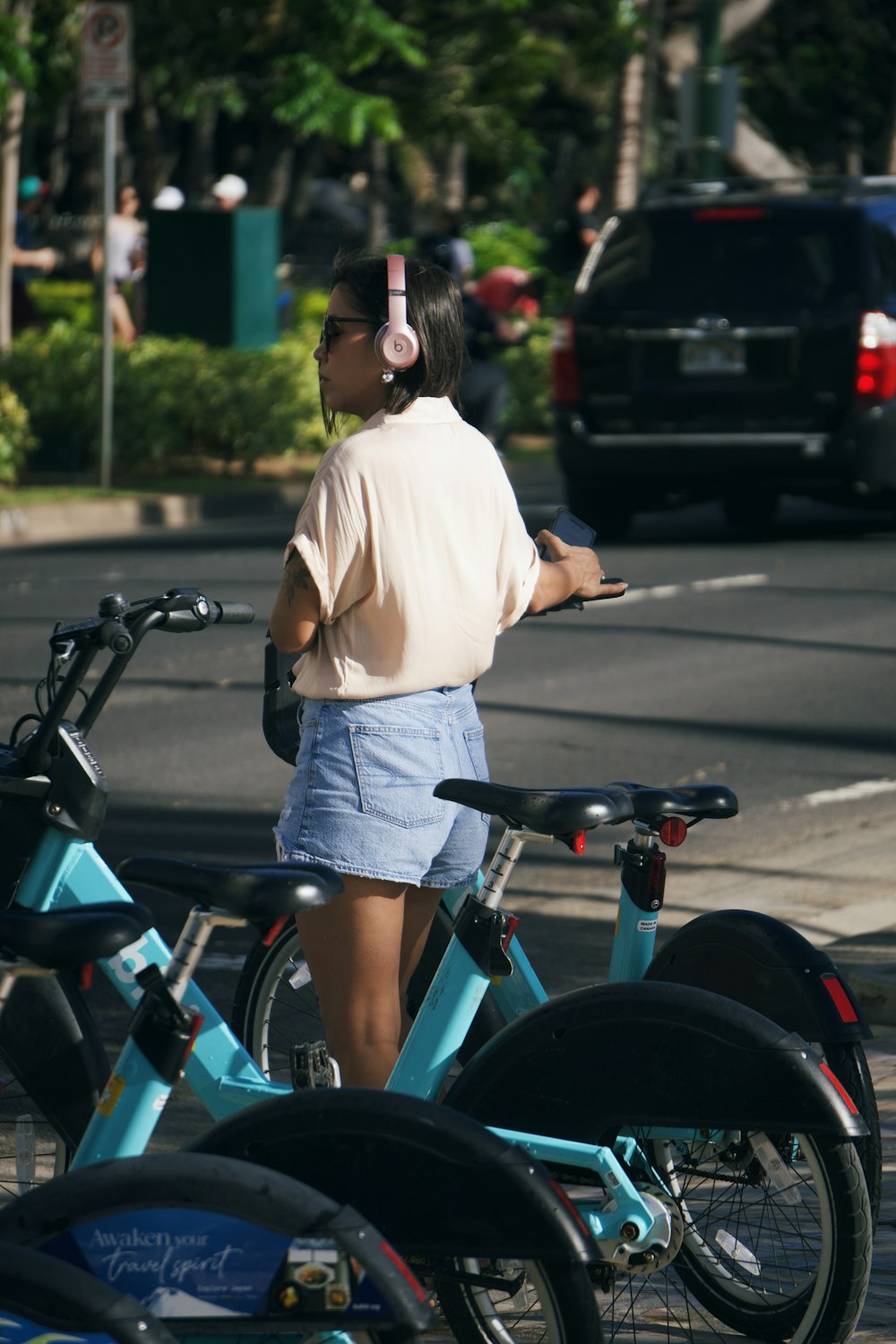 a woman standing next to a row of bikes