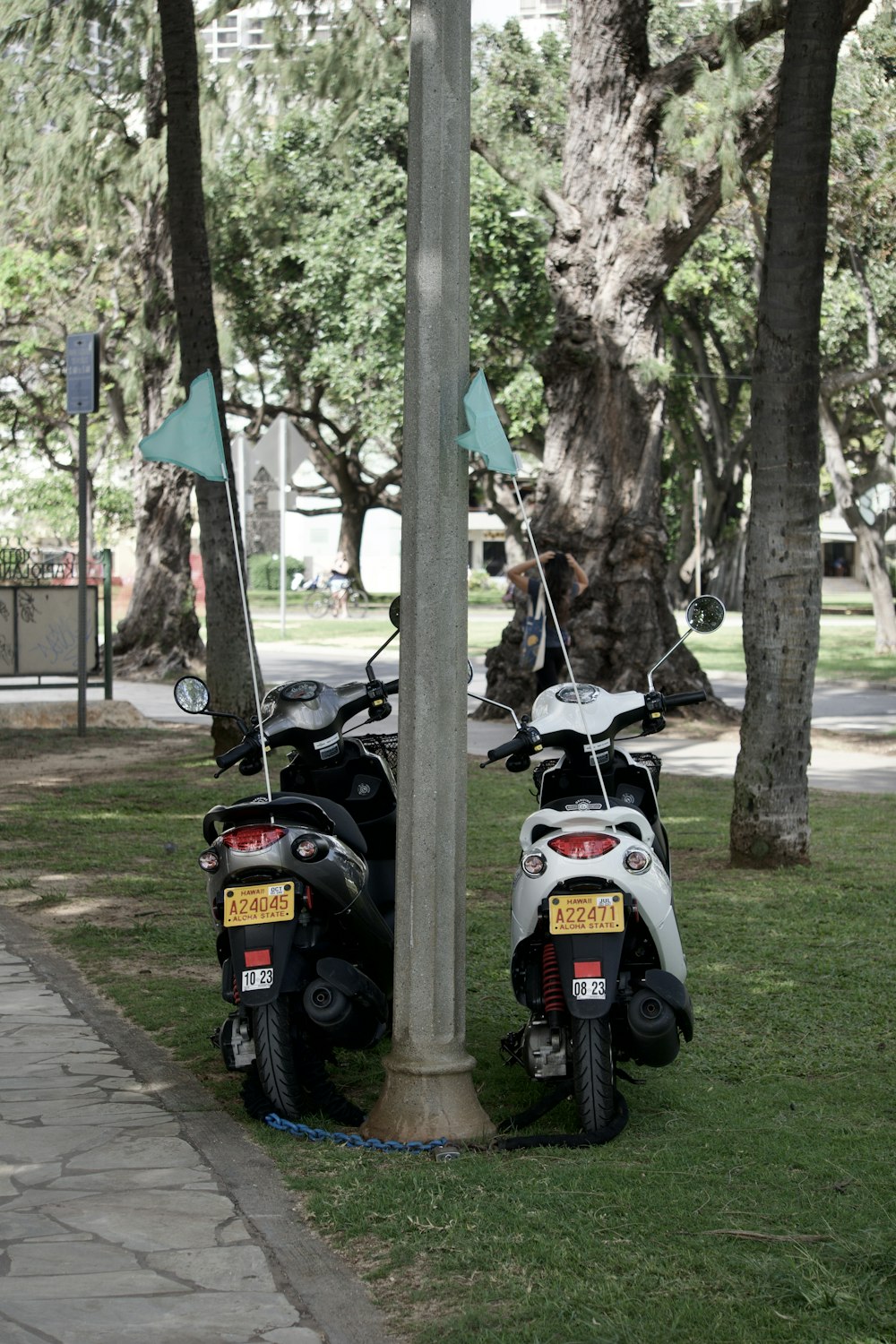 a couple of motorcycles parked next to a pole