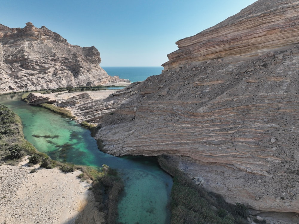 a river flowing between two mountains next to a beach