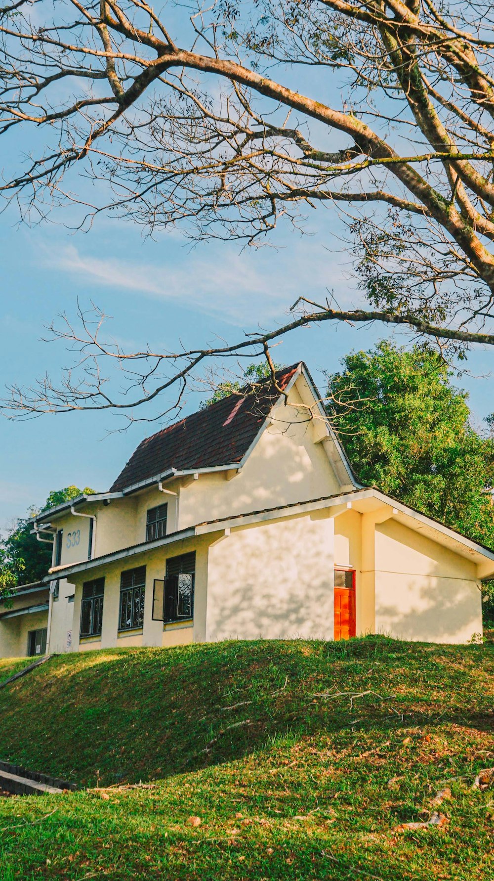 a white house with a red door on a hill