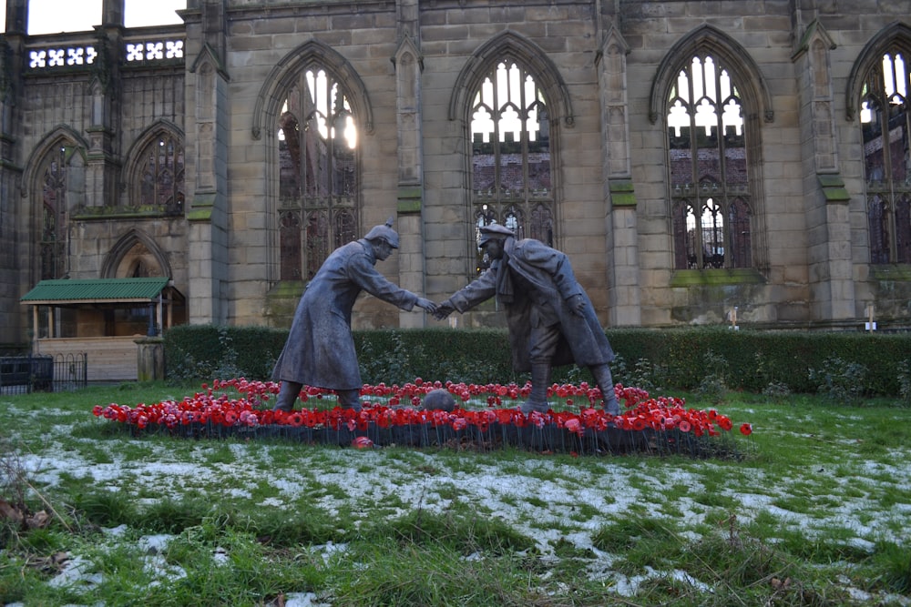 a statue of two people shaking hands in front of a building