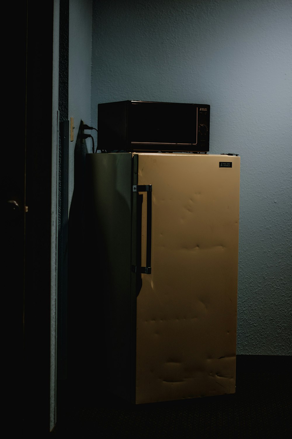 a refrigerator with a microwave on top of it