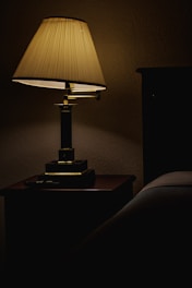 A stylish LED lamp glowing warmly on a bedside table
