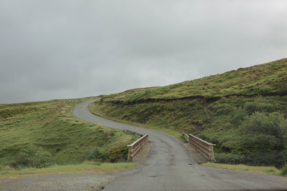 a winding road in the middle of a lush green hillside