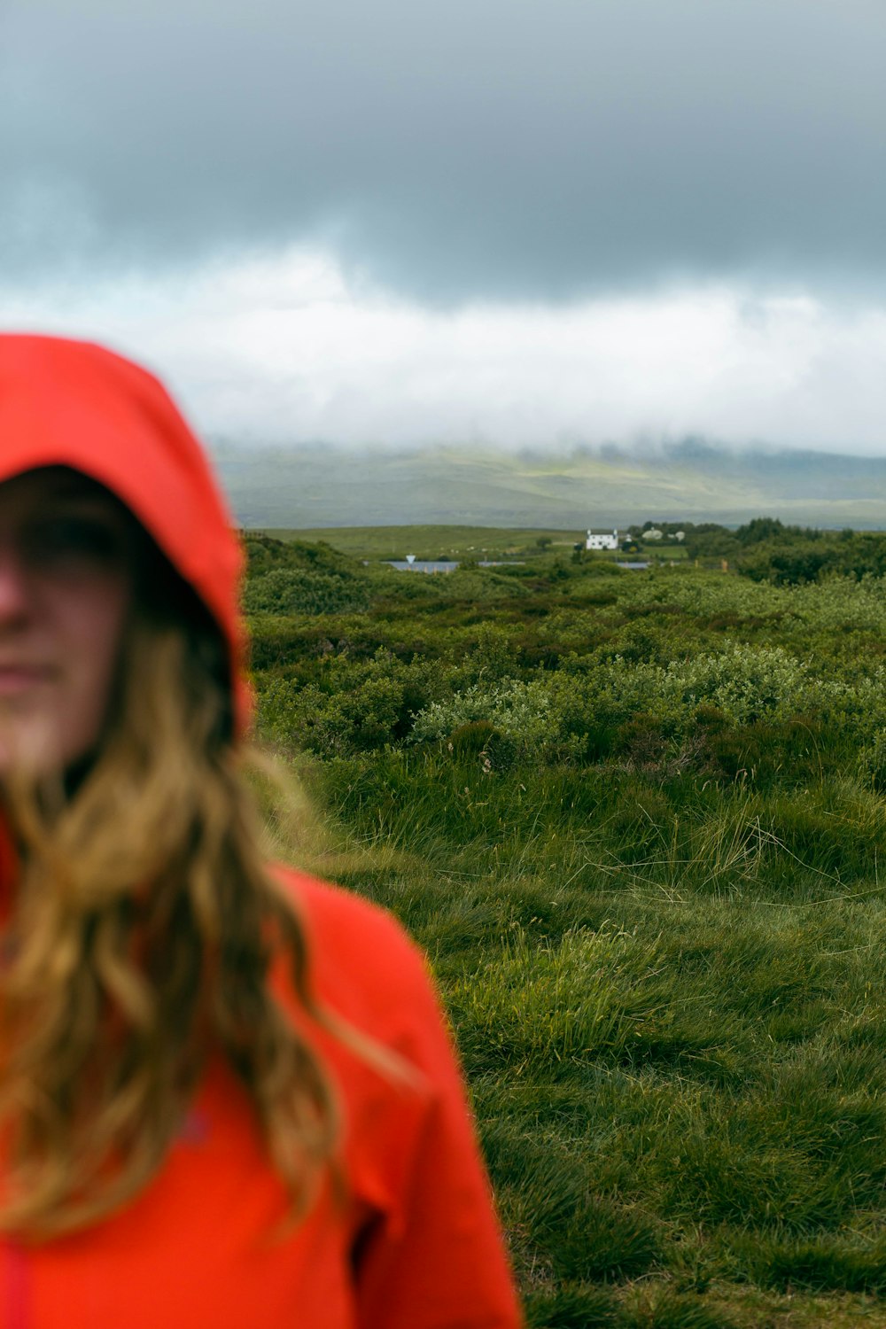 a woman in a red hoodie standing in a field
