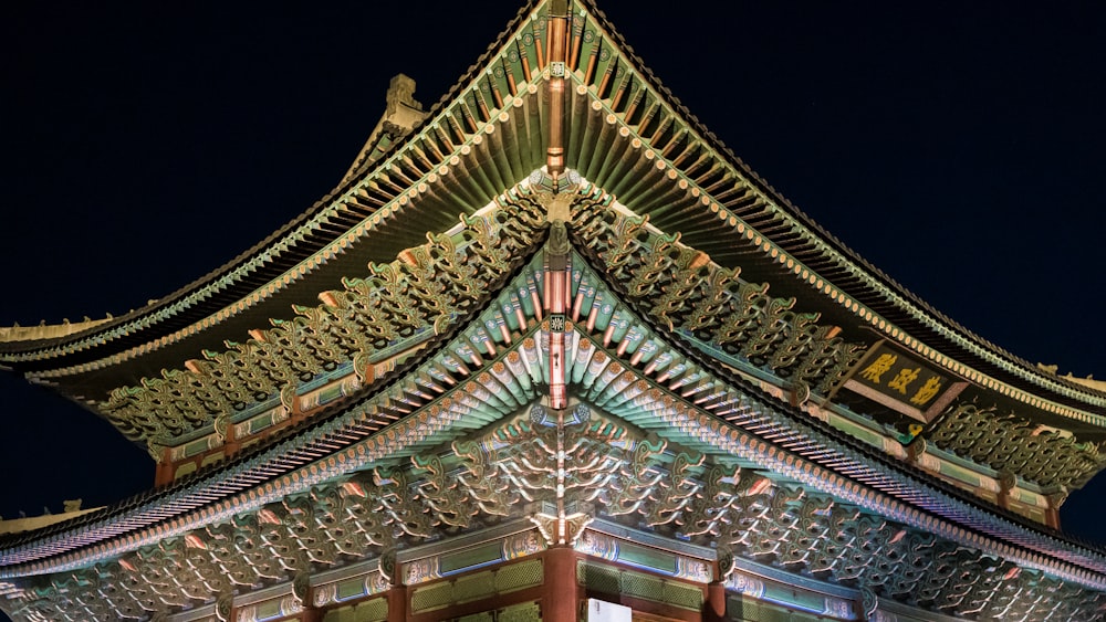 a tall building lit up at night with a sky background