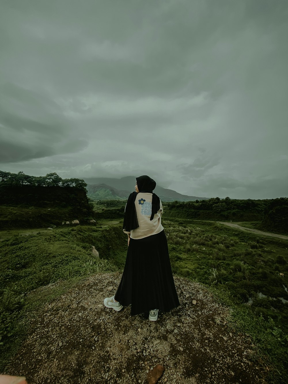 a woman sitting on top of a lush green field