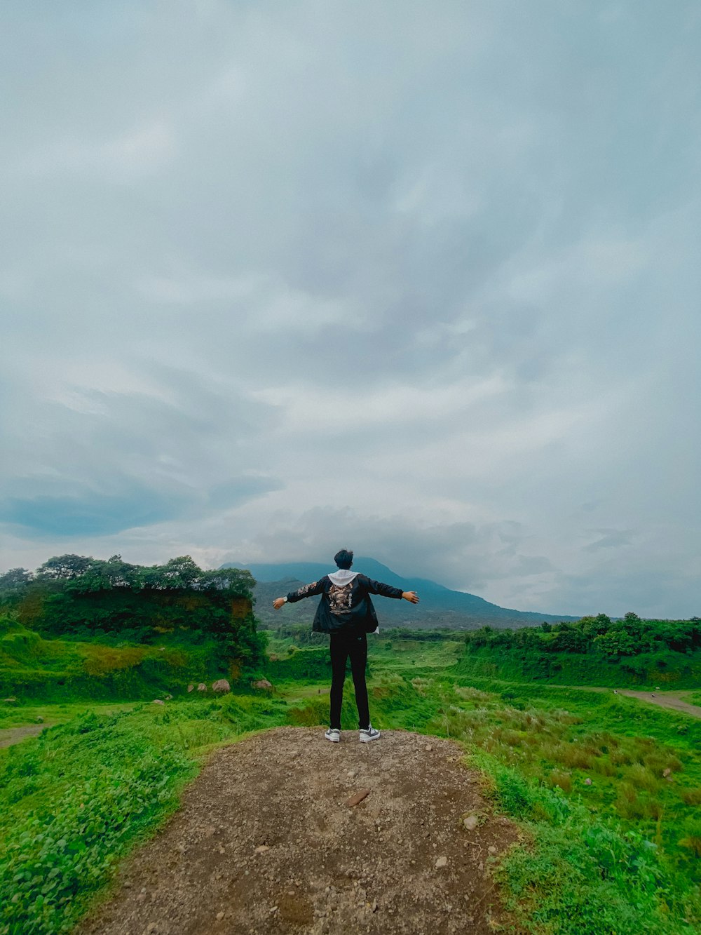 a man standing on top of a dirt road