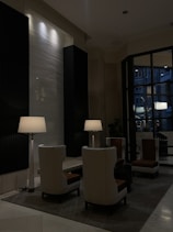 Elegant hotel room seating area with plush chairs and a floor lamp.