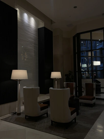 A stylish, dimly lit lounge with elegant seating and soft ambient lighting.