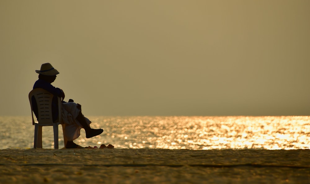 a man sitting in a chair on the beach