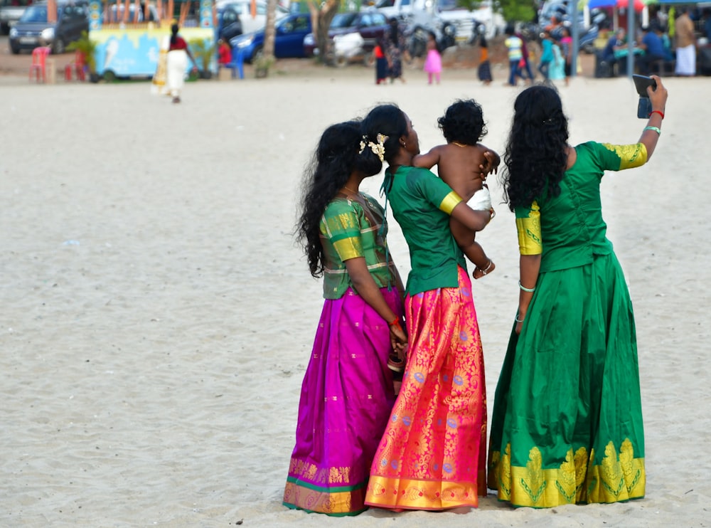 a group of women standing on top of a sandy beach