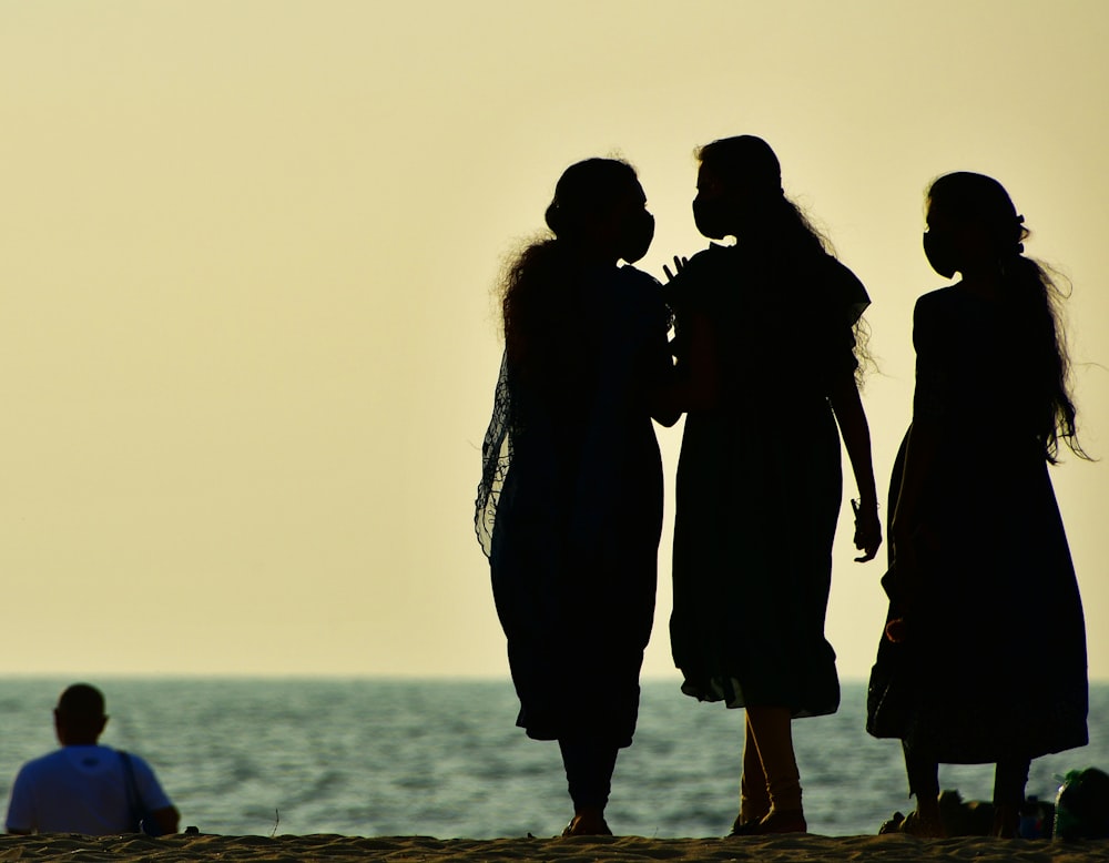 a group of women standing on top of a sandy beach