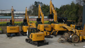 A fleet of trucks and construction machinery lined up at a busy Jinan industrial site.