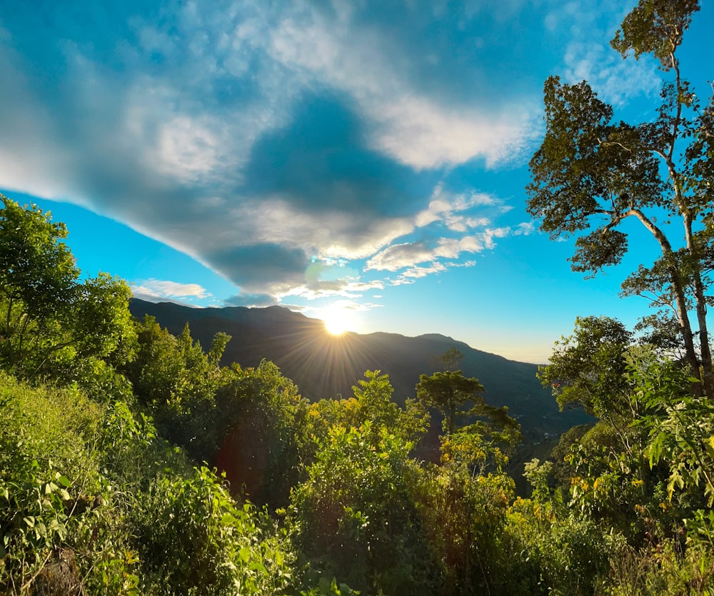 Le soleil brille à travers les nuages au-dessus des montagnes