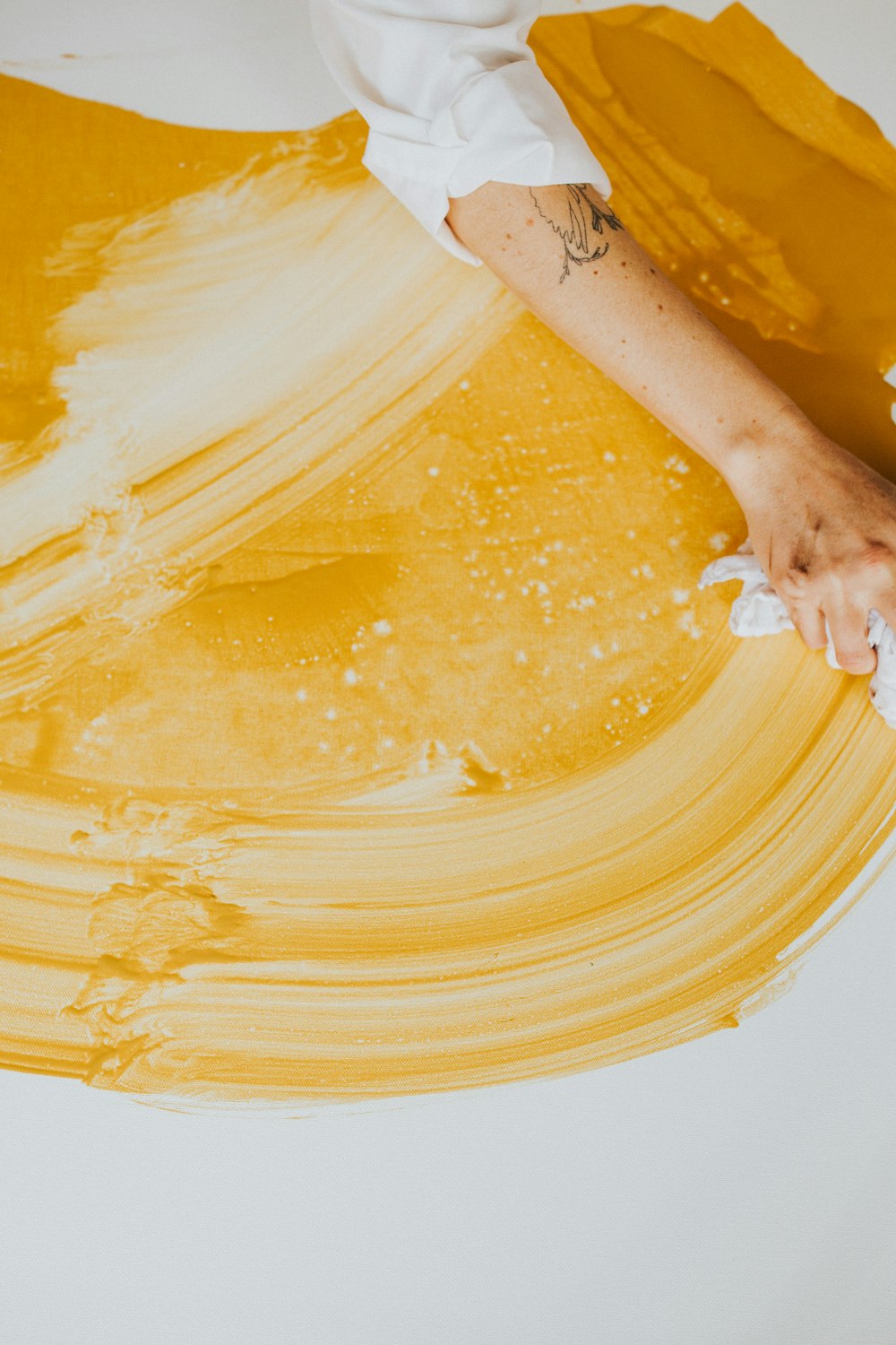 a person is painting a yellow piece of art