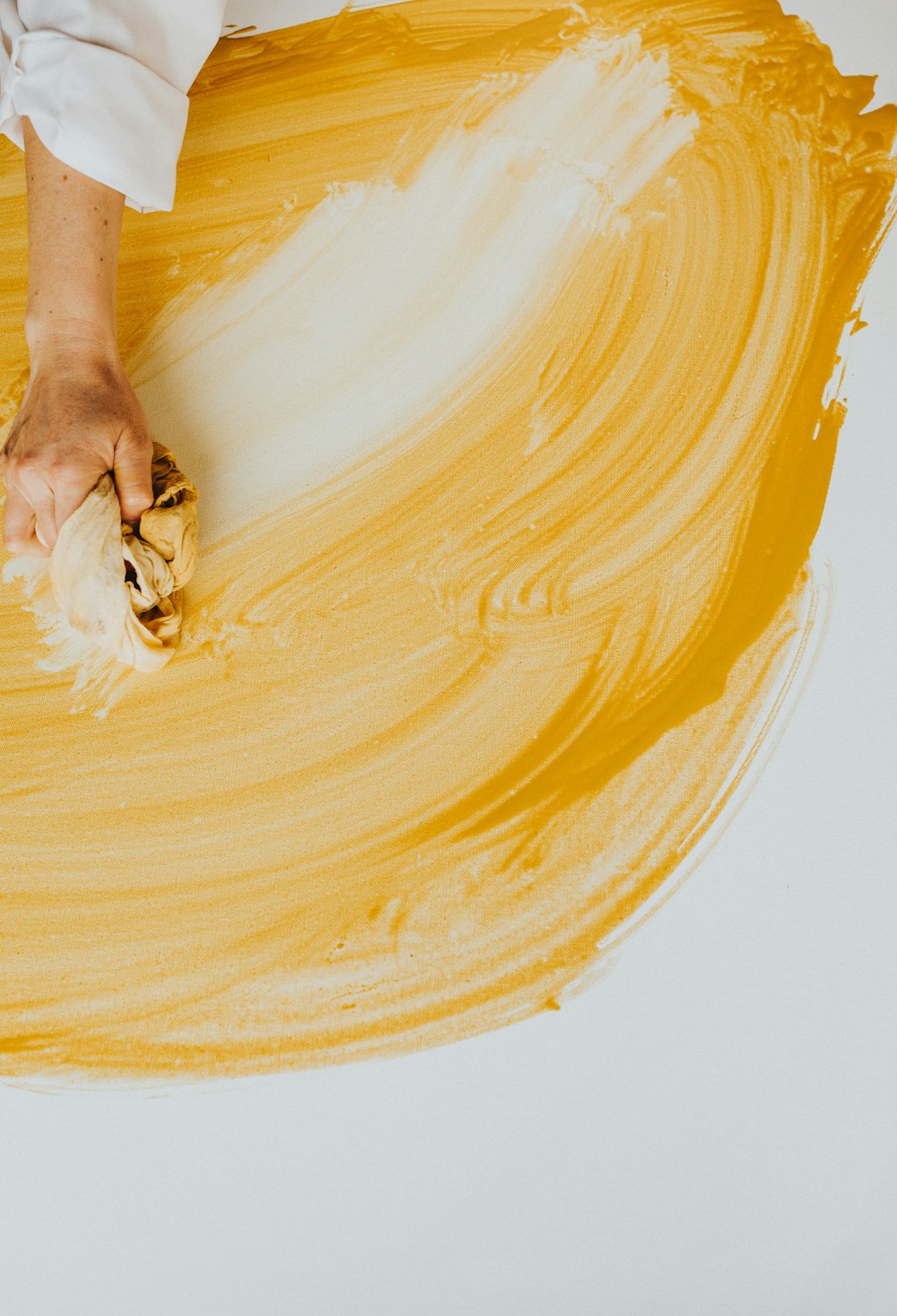 a person is holding a brush and yellow paint