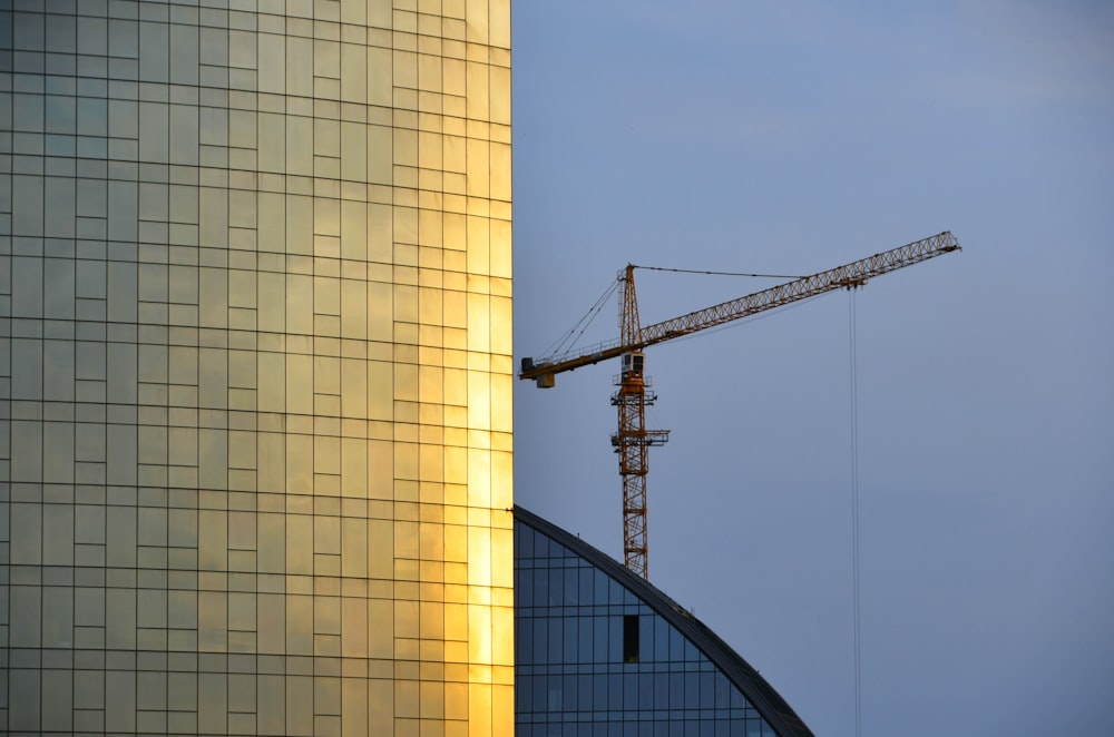 a crane on top of a building next to a tall building