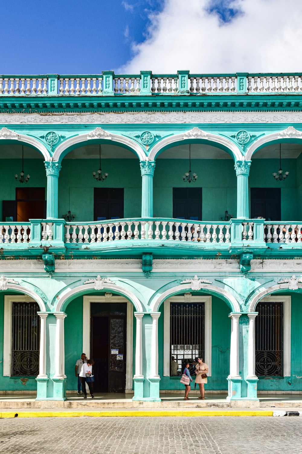 two people standing outside of a building with balconies