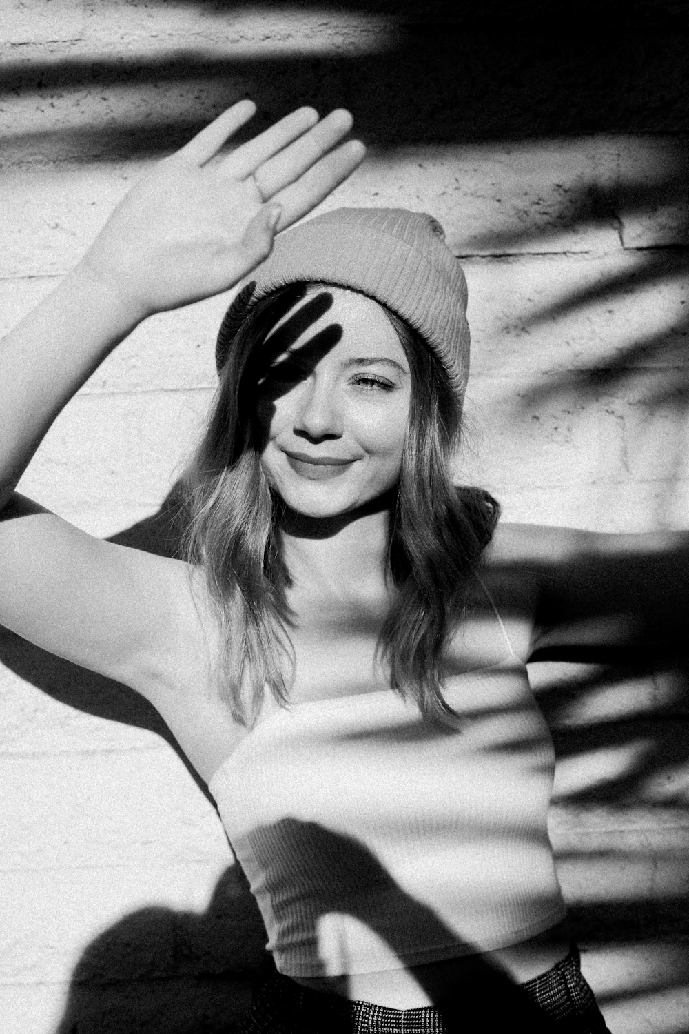 a black and white photo of a woman wearing a hat